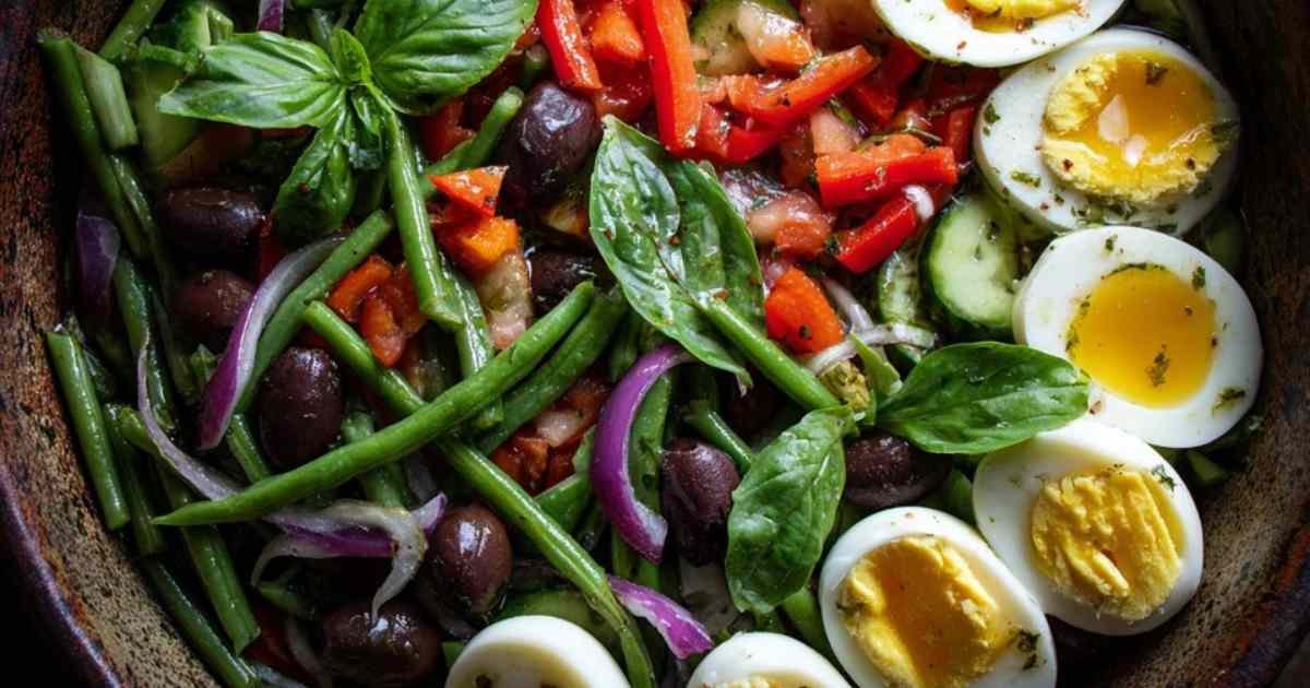 Ingrédients frais pour la salade tunisienne : tomates, concombre, œufs, thon, et haricots.