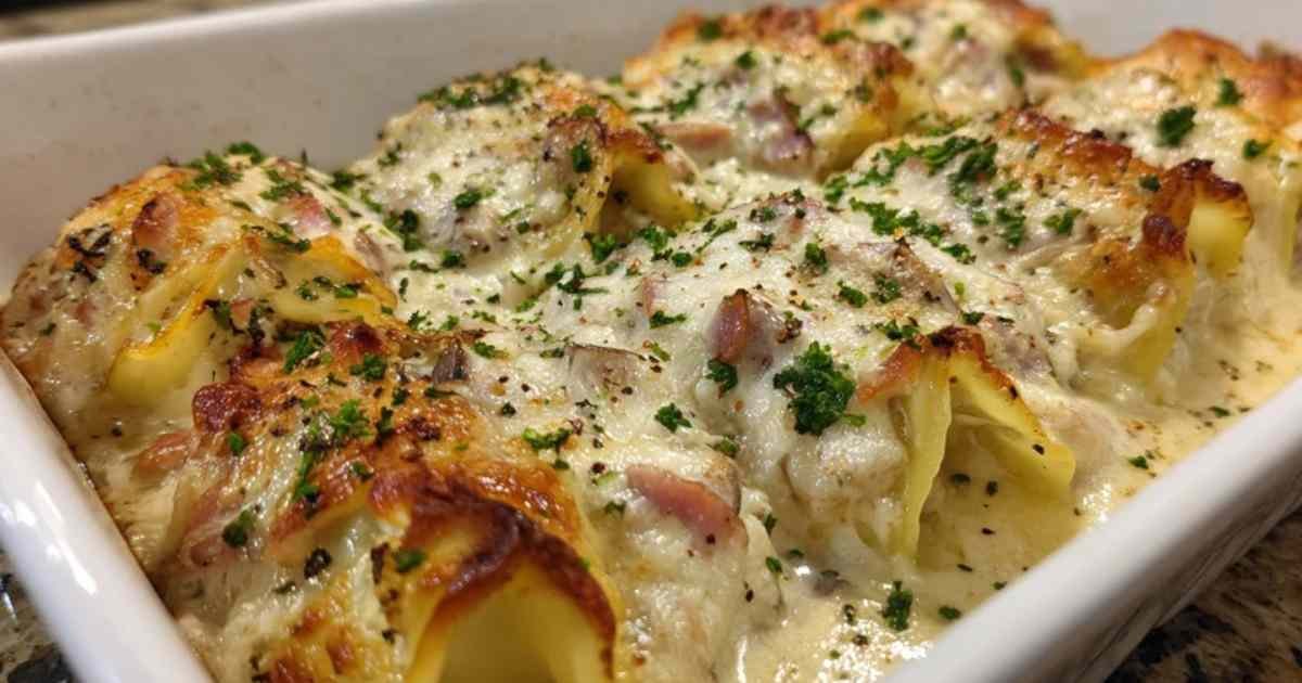 Plat à gratin de lasagnes roulées au jambon et champignons, doré et bouillonnant, saupoudré de persil frais.