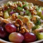 Pain pita ouvert et généreusement garni de salade de poulet aux raisins et noix.
