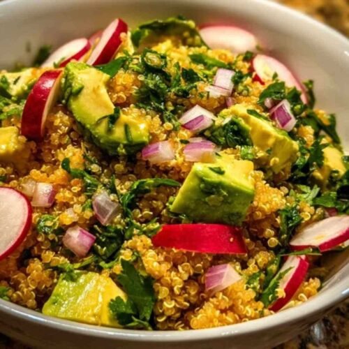 Ingrédients frais pour la salade de quinoa : quinoa, un avocat, des radis, un oignon rouge, un bouquet de coriandre et un citron vert.