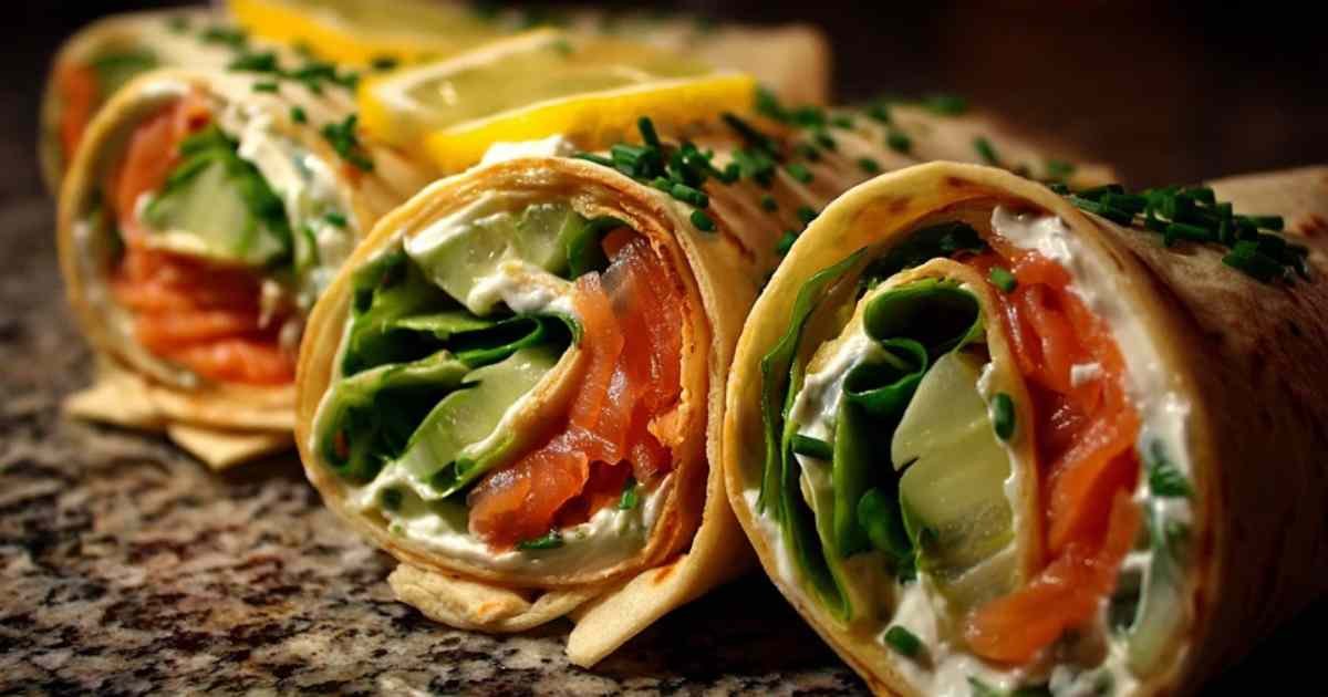 Main en train de rouler un wrap garni de saumon et concombre.