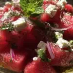Ingrédients salade pastèque feta disposés sur plan de travail en marbre