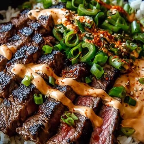 Bol de riz garni de bœuf BBQ coréen tranché, légumes colorés et sauce crémeuse épicée