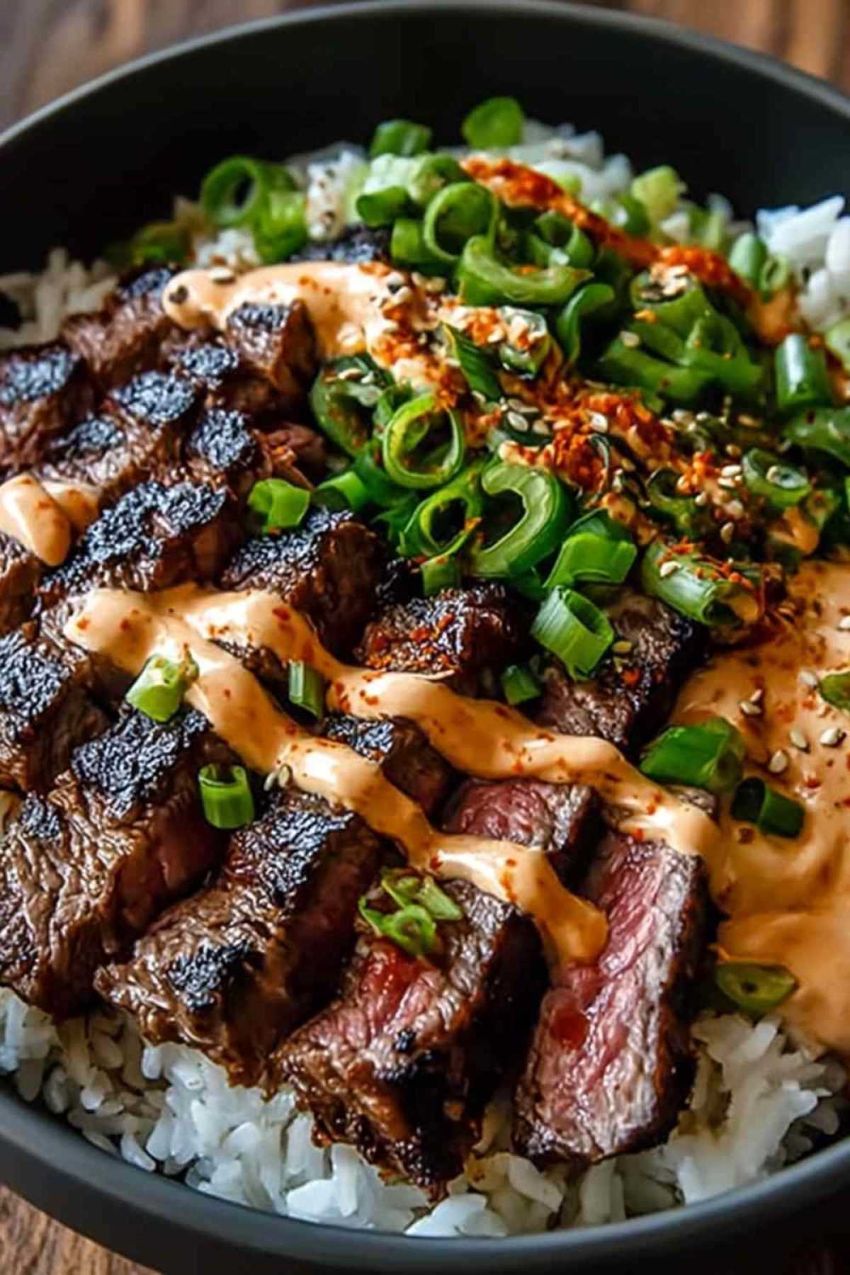 Bol de riz garni de bœuf BBQ coréen tranché, légumes colorés et sauce crémeuse épicée