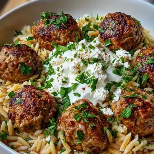 Boulettes grecques dorées avec orzo citronné et crème de feta dans une assiette