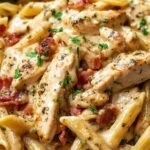 Assiette de pâtes penne au poulet crémeuses avec parmesan et herbes fraîches