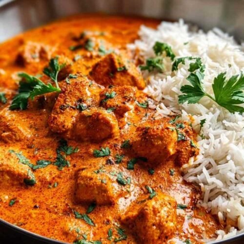 Poulet tikka masala dans une casserole avec sauce crémeuse orange