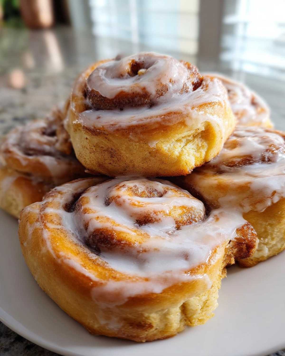 Gros plan de plusieurs roll-ups cannelle keto glacés, parfaits pour un dessert faible en glucides.