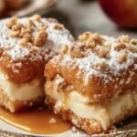 Deux beignets gâteau entonnoir garnis de crème, saupoudrés de sucre glace et de noix, nappés de caramel.