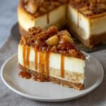 Gros plan d'une tranche de cheesecake aux pommes caramel salé, nappée de sauce caramel et garnie de morceaux de pommes.