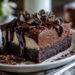 Gros plan d'une tranche de Gâteau Réfrigéré aux Brownies Facile, garnie de chocolat et de sauce au chocolat.
