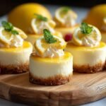 Gros plan sur des mini cheesecakes au citron facile, garnis de crème fouettée, d'une tranche de citron et de menthe.