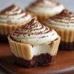 Gros plan d'une recette de Tiramisu Cups individuelle avec une bouchée, garnie de crème et de cacao.