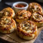 Gros plan sur des rouleaux de pizza au levain garnis de sauce tomate et de fromage fondant, saupoudrés d'herbes.